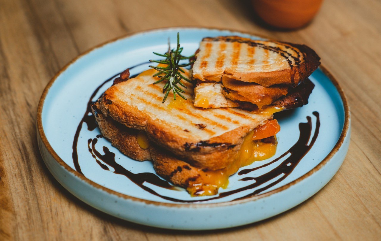 Grilled cheese on light blue plate with balsamic