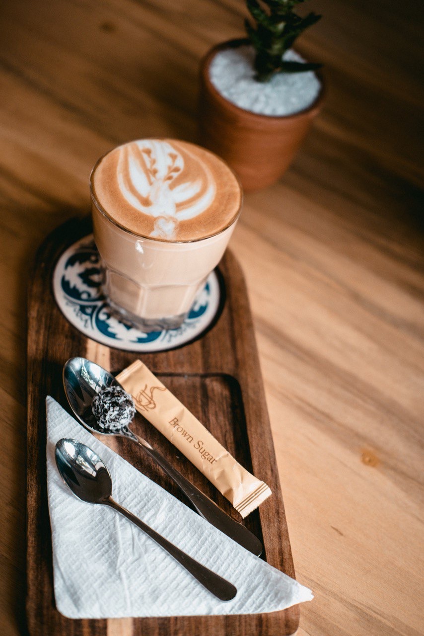 Latte on wooden tray with azulejo coaster